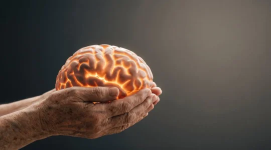 Elderly hands holding a luminous brain model against soft natural light, symbolizing cognitive reserve and brain resilience despite Alzheimer's pathology