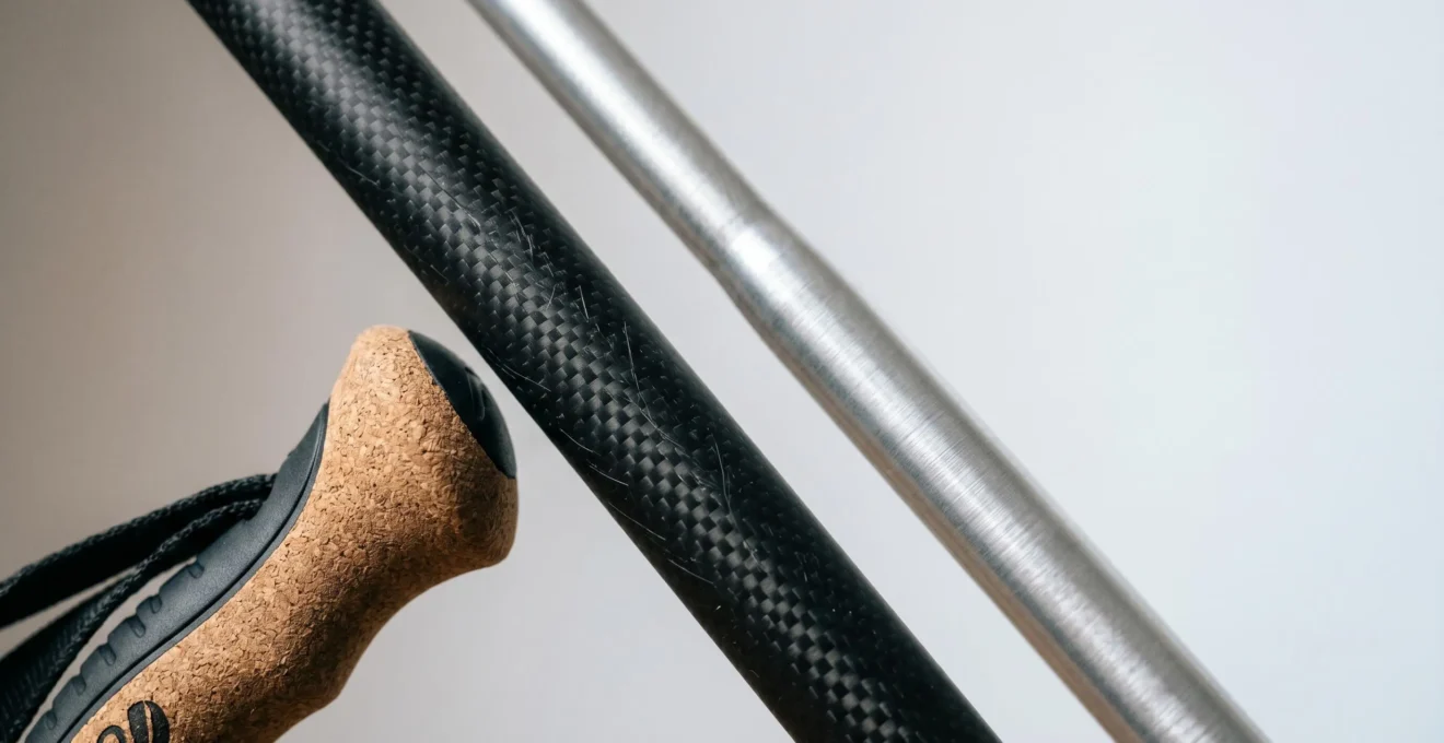 Close-up comparison of carbon fiber and aluminum walking pole shafts with ergonomic handles, showcasing material texture and grip design for arthritis relief