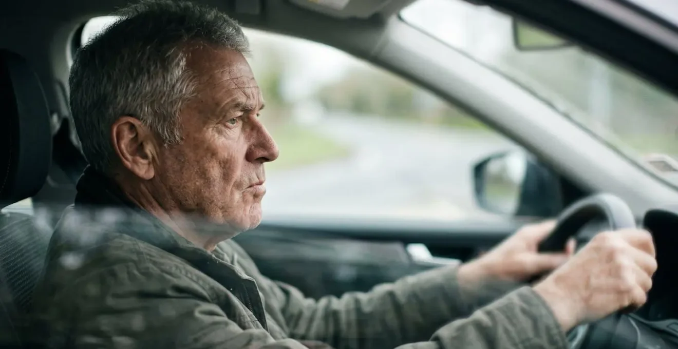 Senior driver concentrating during vision assessment, highlighting the critical relationship between aging eyes and safe driving after age 70