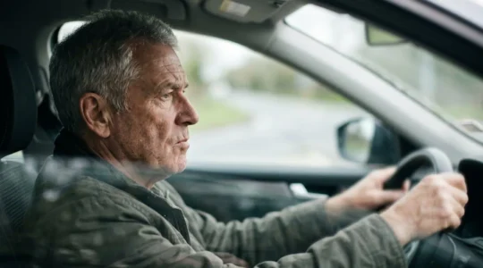 Senior driver concentrating during vision assessment, highlighting the critical relationship between aging eyes and safe driving after age 70