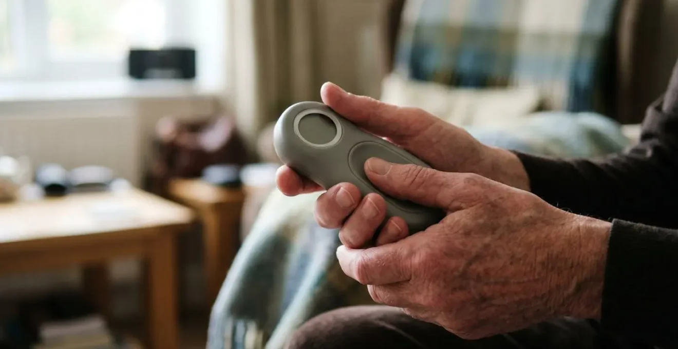 A senior's hands gently holding a modern health tracking device, symbolizing proactive health monitoring and weekly vital signs awareness
